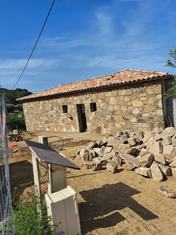 Maison en pierre avec toit en tuiles, pierres taillées au premier plan