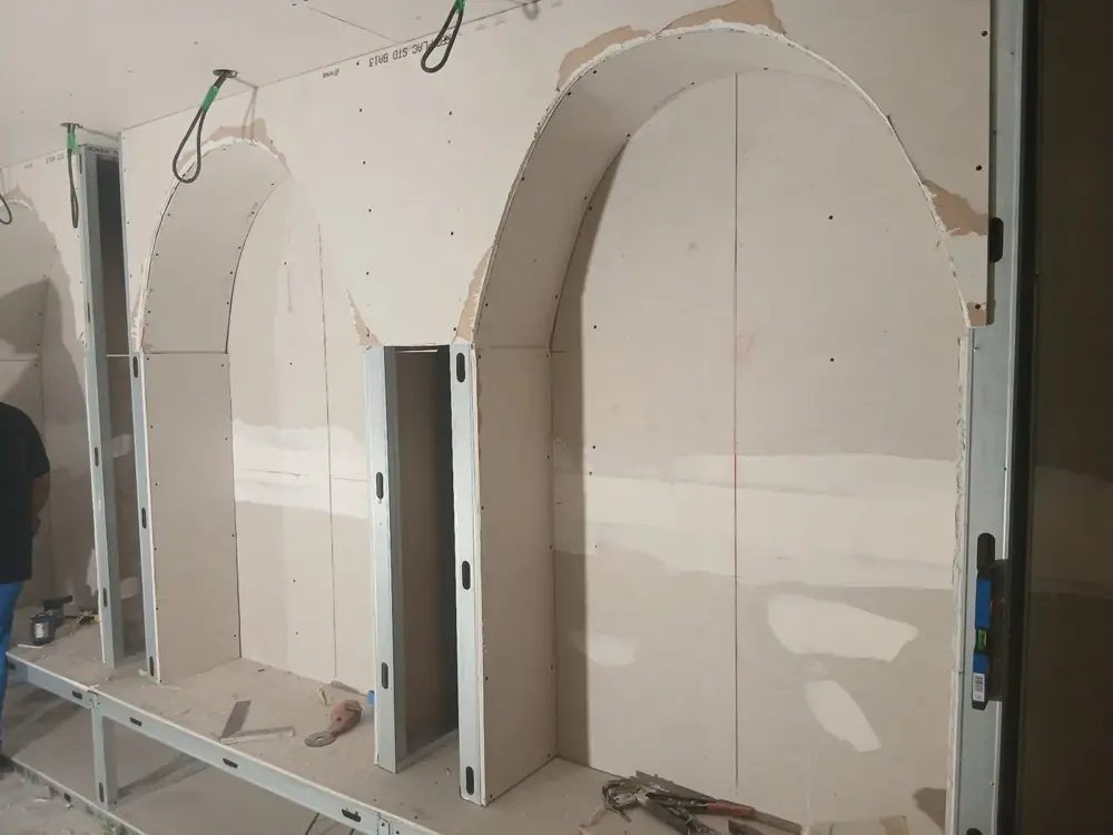 Cloisons en plaques de plâtre formant des arches dans une pièce en travaux