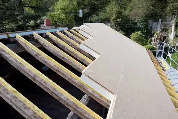 Pose de panneaux isolants et de liteaux sur une toiture